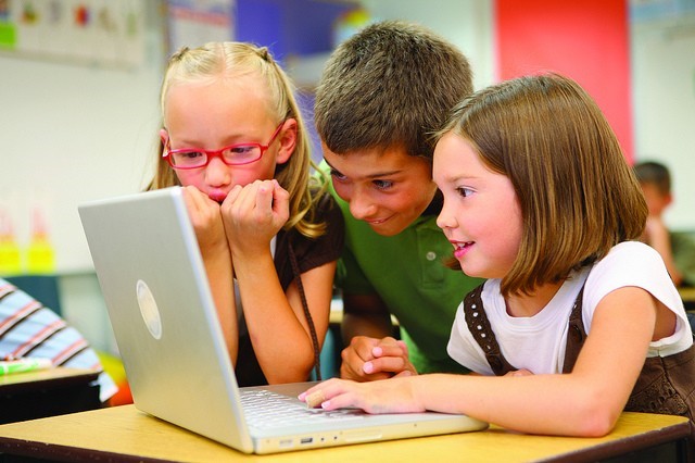 Children work together on a laptop